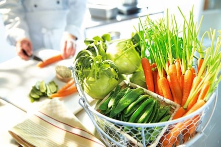 Drahtkorb mit jungen Karotten, Erbsenschoten und Kohlrabi