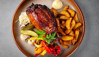 Vepřové koleno s americkými brambory a nakládanou zeleninou