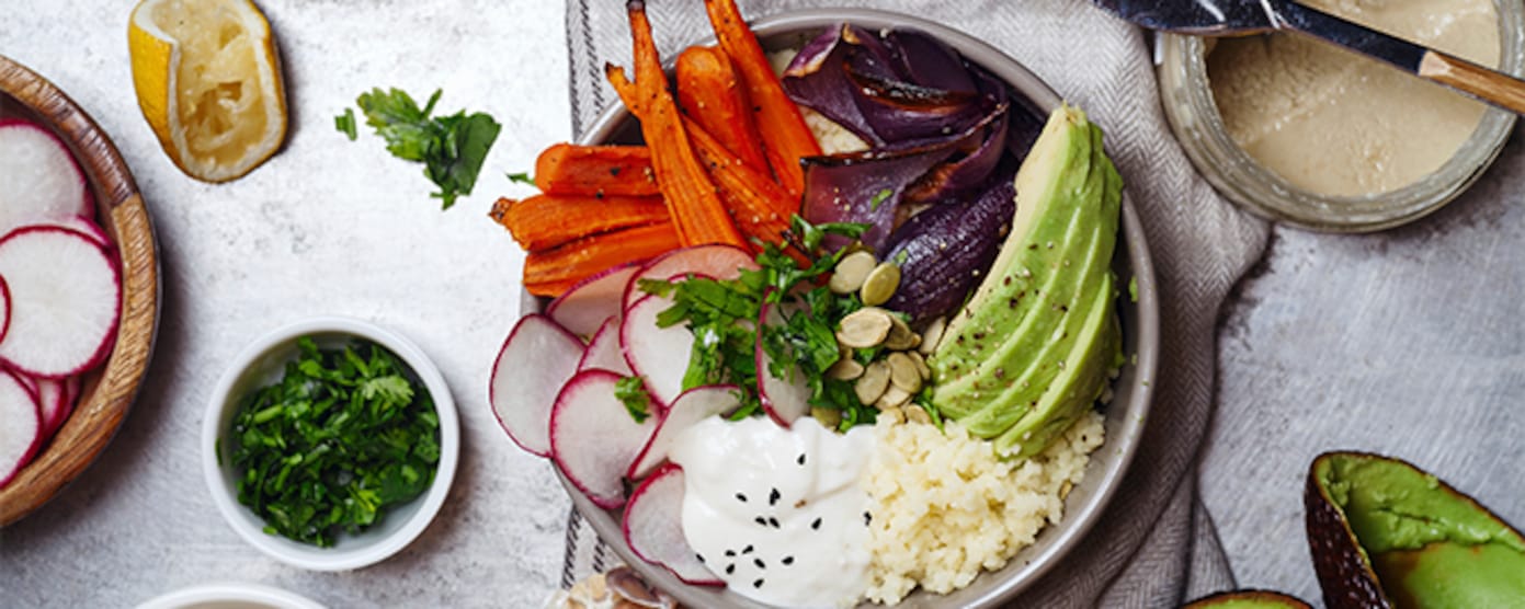 Lunch Bowl mit Couscous, Karotten, Zwiebeln, Radieschen und Avocado