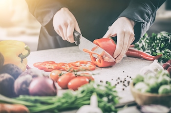 Restaurant eröffnen – Personal schneidet Gemüse in der Restaurantküche