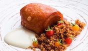 Cochinillo asado crujiente con migas al pastor, cebolla encurtida y tomatitos