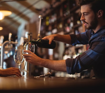 Barman servant un verre à son comptoir