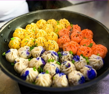 Baos cuits dans un wok dans un stand de street food à New-York