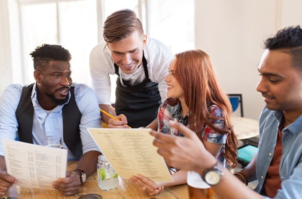 Serveur expliquant la carte à ses clients