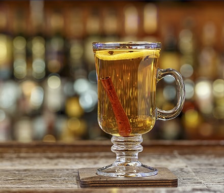 Verre de grog avec un bâton de cannelle dedans