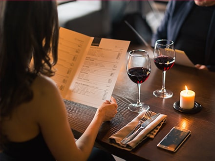 Femme regardant le menu à la table d'un restaurant