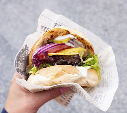 Burger végétarien tenu dans dans une main