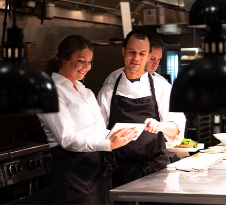 Deux restaurateurs regardant leurs stocks sur une tablette