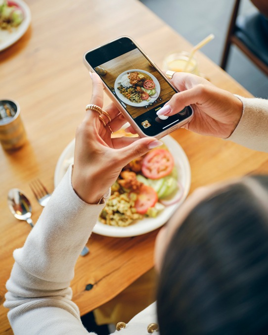 La cliente satisfaite prend en photo son plat pour les réseaux sociaux.