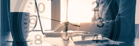 Homme sur un ordinateur avec une horloge en surimpression Homme sur un ordinateur avec une horloge en surimpression