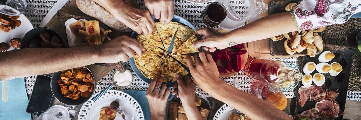 Repas convivial où tout le monde se sert dans le même plat