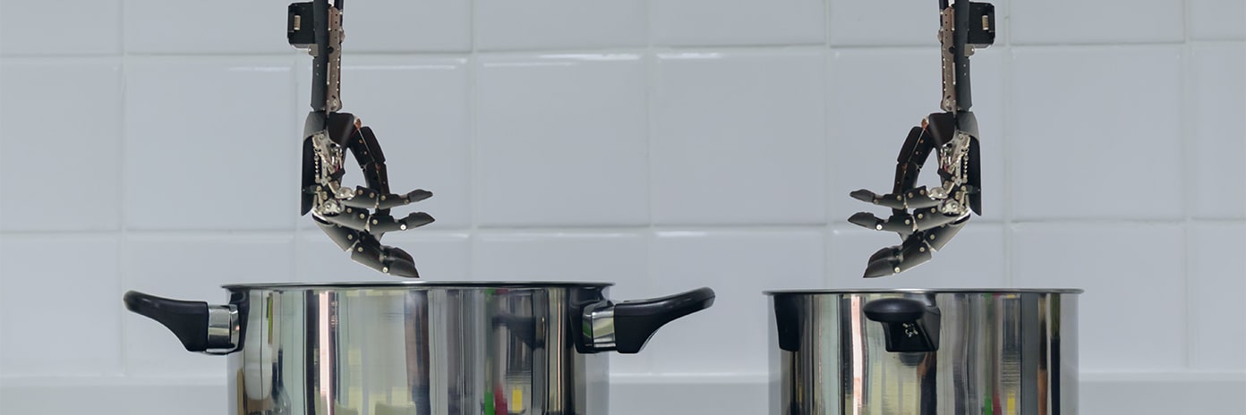 Mains robotiques au dessus de casseroles