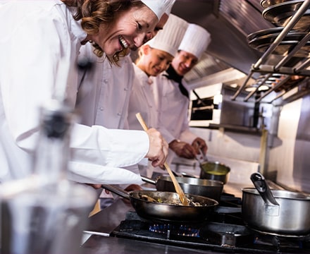Femme cheffe en cuisine avec son équipe