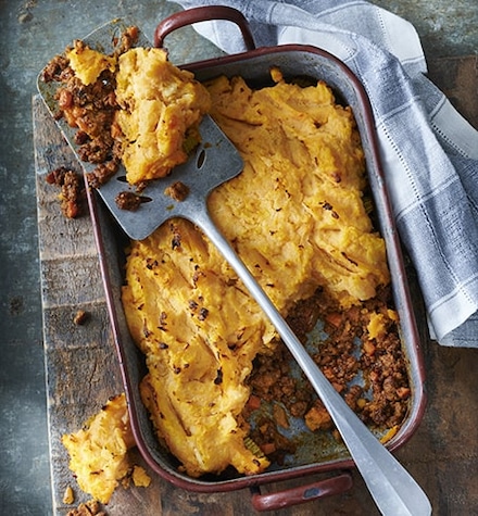 Un plat composé de viande hachée sur une planche en bois