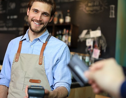 Serveur souriant effectuant un paiement CB