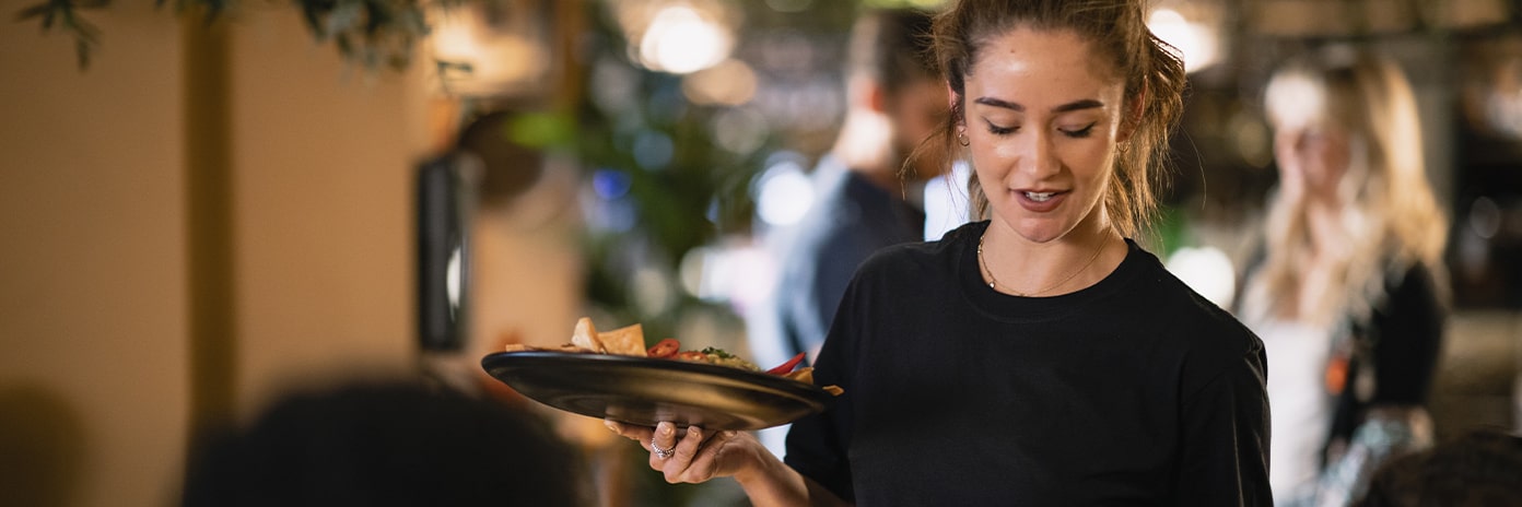 Serveuse souriante apportant des plats