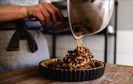 Mélange de tarte aux noix de pécan versé dans un moule à pâtisserie