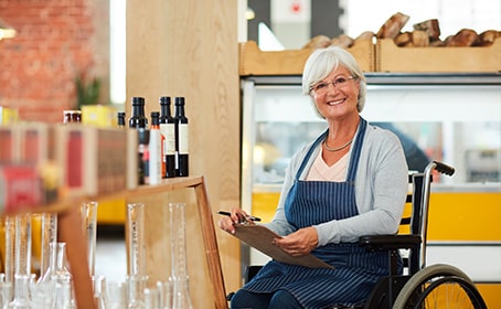 Femme senior en fauteuil roulant qui travaille dans un restaurant