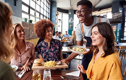 Serveur souriant à la table de clientes
