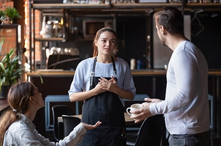 Clients qui échangent avec la serveuse dans un restaurant