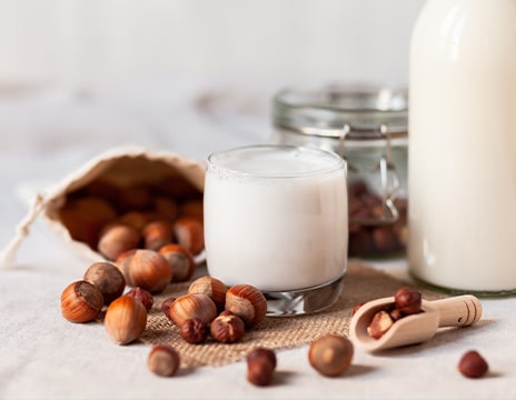 Verre de lait de noisette et sac de noisettes