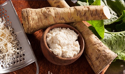 Racines de raifort et pâte de raifort dans un bol