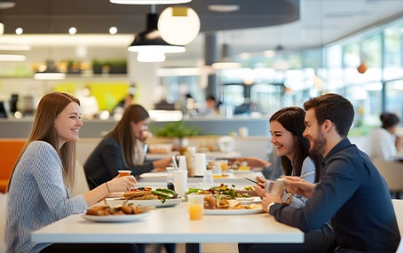 Trois personnes déjeunent à la cantine