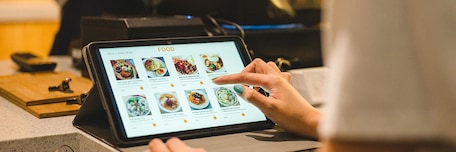 Client qui fait sa commande sur une tablette dans un restaurant Client qui fait sa commande sur une tablette dans un restaurant