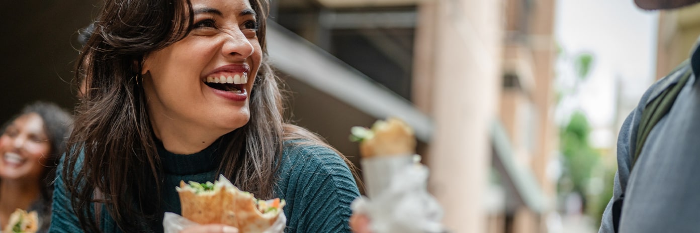 Jeune femme qui mange un sandwich en extérieur