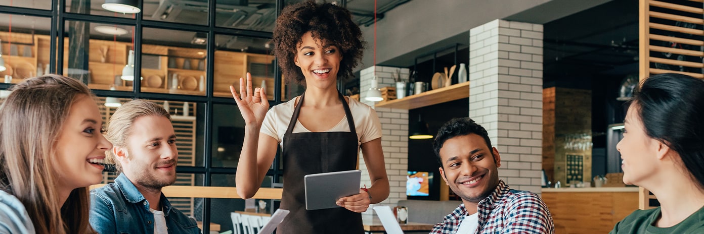 Une serveuse prend les commandes des clients à table