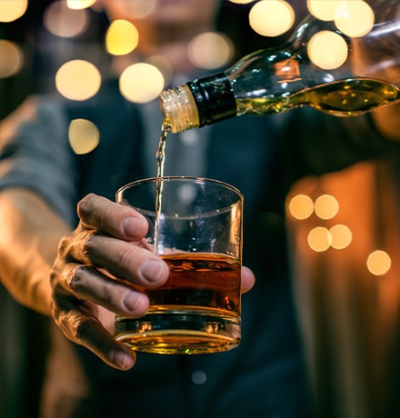 Barman versant du whisky dans un verre