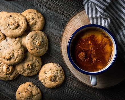 Cookies au chocolat avec une tasse de café sur une table