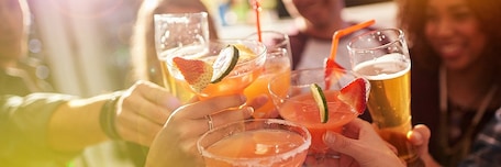 Groupe de personnes qui trinquent avec des cocktails