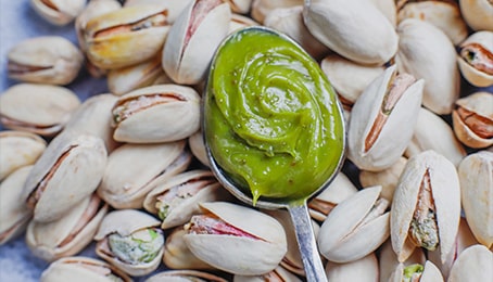 Cuillère avec de la crème ou pâte de pistache