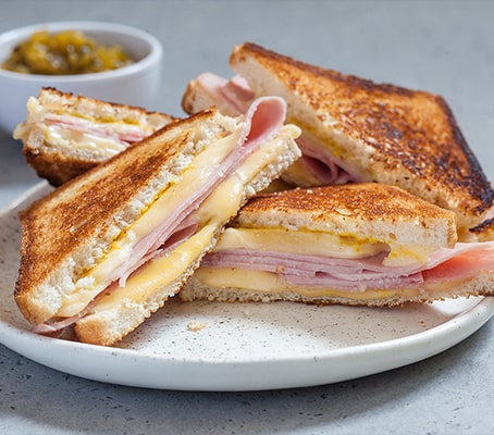 Croque monsieur coupé en triangle  sur une assiette blanche