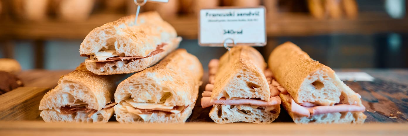 Sandwichs fraîchement préparés exposés sur le comptoir en bois d’une boulangerie
