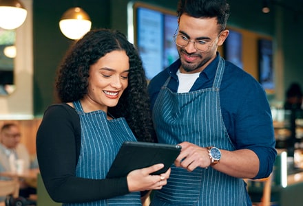 Deux restaurateurs discutent avec une tablette dans les mains