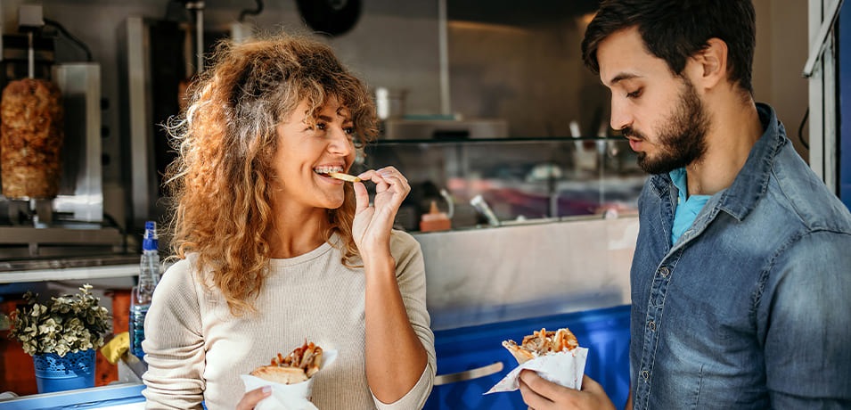 Un homme et une femme qui mangent un kebab
