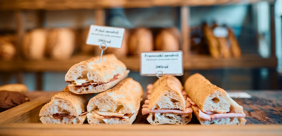 Sandwichs fraîchement préparés exposés sur le comptoir en bois d’une boulangerie