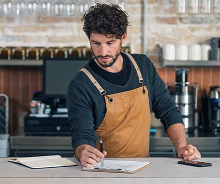 Serveur de restaurant qui prend des notes sur une feuille