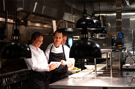 Personnel dans une cuisine de restaurant qui consulte une tablette