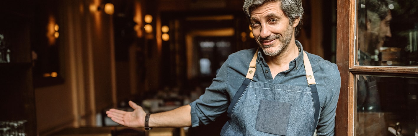 Un restaurateur invite ses clients à entrer dans son établissement