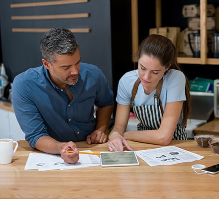 Un homme et une femme étudiant des graphiques sur une tablette