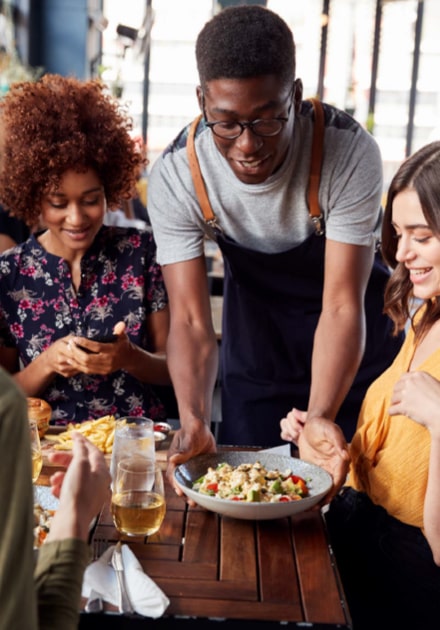 Serveur de restaurant apportant un plat à un client