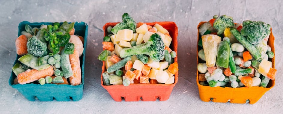 Légumes surgelés disposés dans les récipients de couleur