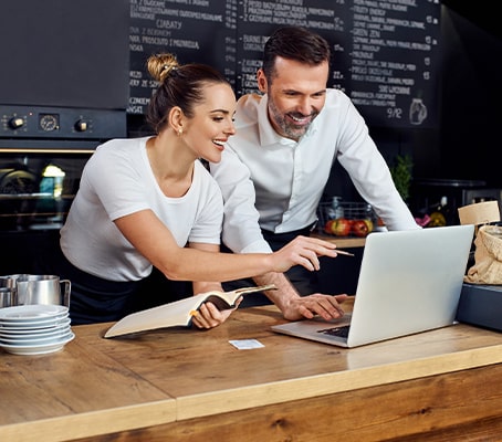 Analyse de données sur un ordinateur par la gérante et le gérant d'un restaurant