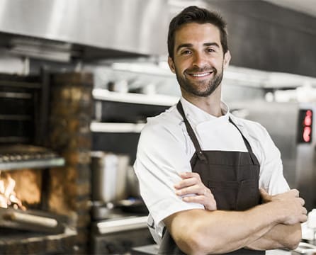 Restaurateur posant dans la cuisine de son restaurant