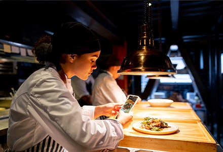 Chef qui prend une assiette en photo