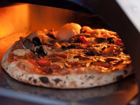 Cuisson d’une pizza dans un four à pizza