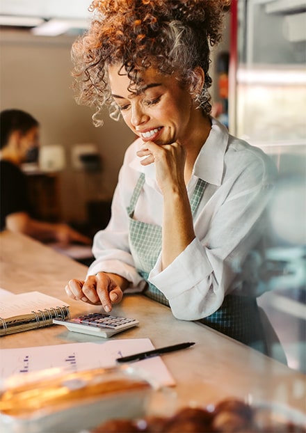 Une restauratrice fait un calcul à l’aide d’une calculette